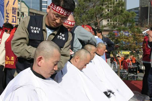 지난 13일 서울역 광장에서 철도노조 간부들이 정부의 일방적인 철도 구조조정에 반대하여 삭발식을 진행하고 있다 